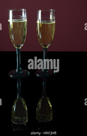 Two glasses of champagne on black table with reflection. Stock Photo
