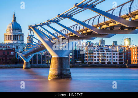 Evening light falls on the Millennium Bridge and St. Paul's Cathedral in London.