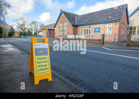 Stopping here could endanger a child's life signs. A school no parking safety zone, Southport, UK Stock Photo