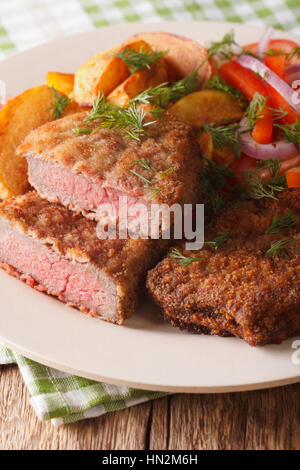 Fried rump steak and fresh vegetables, baked potatoes close up on a plate. vertical Stock Photo