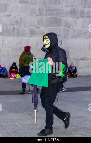 Protestor wearing Guy Fawkes mask carries sign reading Defend Planned Parenthood in the Women's March on Washington, DC on January 21, 2017