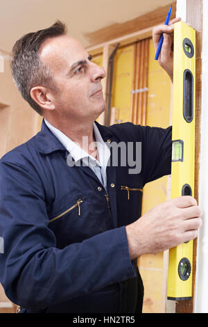 Builder Checking Work With Spirit Level Stock Photo