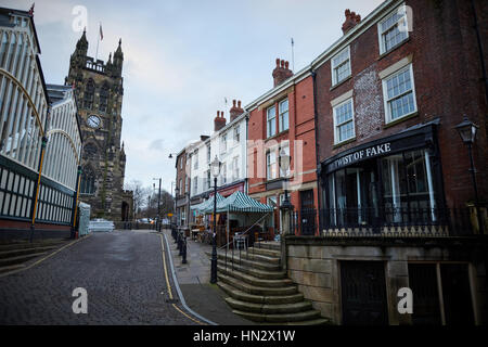 Landmark St Mary's Church on Stockport Market on a dull winter day showing the exterior of the Indoor Market Hall and independent shops in historic bu Stock Photo