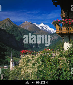 Tirolean house with balcony in Heiligenblut, snow capped Grossglockner mountain in distance, Carinthia, Austria. Stock Photo