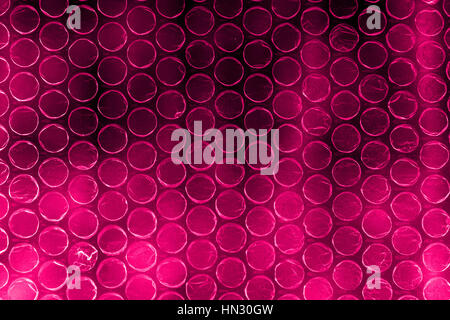 Plastic polymer bubble wrap in high contrast vivid reddish pink color Stock Photo