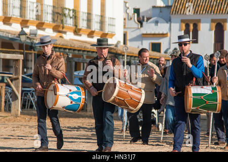 Procession with drummers and pilgrims walking through sandy street in El Rocío, Almonte, Province of Huelva, Andalucia, Spain Stock Photo