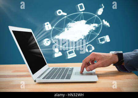 Businessman scrolling laptop mouse against blue Stock Photo