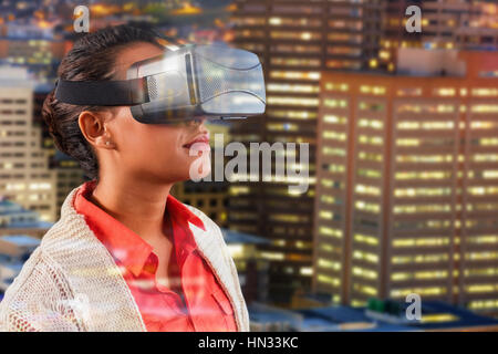 Close up of teacher holding virtual glasses against illuminated buildings in city Stock Photo