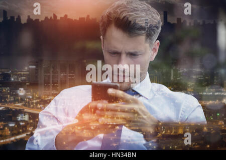 Close up of thoughtful businessman using mobile phone Stock Photo