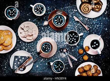 Tea party of astronomers, where the stars are reflecting in cups. Still life image shot from above. Stock Photo