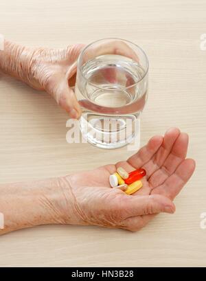Close-up of aged hands taking the pills Stock Photo