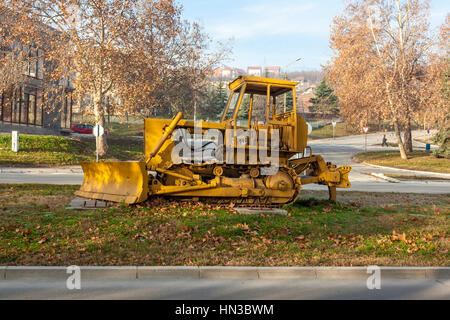 Bor, Serbia,- December 12, 2015: Old yellow bulldozer placed as a monument in the industrial city Stock Photo