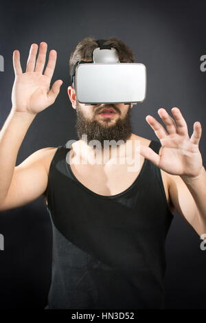 Scared bearded man wearing VR glasses Stock Photo