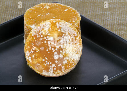 Traditional Sliced brown coconut sugar on black dish Stock Photo