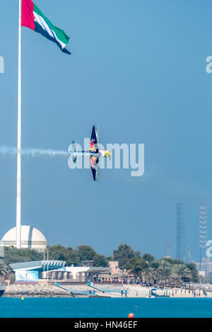 Abu Dhabi, United Arab Emirates.  8th Feb 2017.  Practice flight for the Abu Dhabi leg of the 2017 Red Bull Air Races.  Aircraft is flying past flag of the UAE which dominates the city's corniche.  Race days are 10 and 11 February 2017.  Credit: Richard Sharrocks / Alamy Live News. Stock Photo