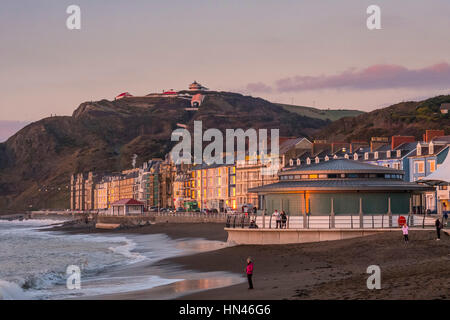 Aberystwyth, Wales, UK. 8 February 2017.  At the end of a gorgeous spring-like day, the light of the setting sun is reflected from seafront buildings, including the towns new bandstand. Credit: Alan Hale/Alamy Live News Stock Photo