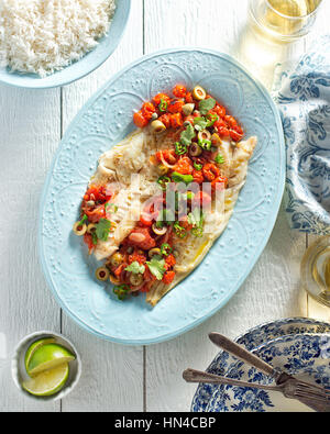 Delicious white fish veracruz with olives, capers, tomato, jalapeno pepper and cilantro. Stock Photo