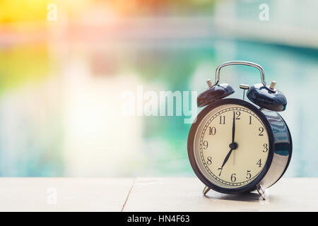 7 o'clock retro clock at the swimming pool outdoor holiday time concept. Stock Photo