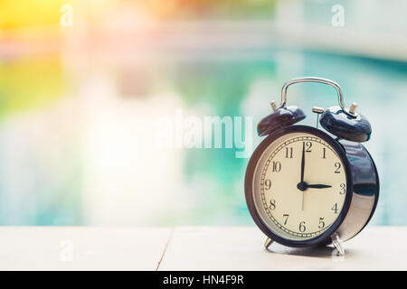 3 o'clock retro clock at the swimming pool outdoor holiday time concept. Stock Photo