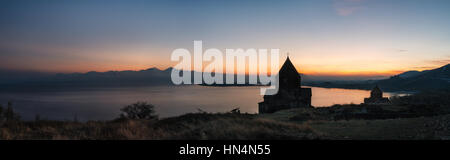 Panoramic view of the temple complex on the Sevan Lake at sunset, Armenia. Silhouettes of St. Jakob Church and Sevanavank. Armenian landmarks Stock Photo