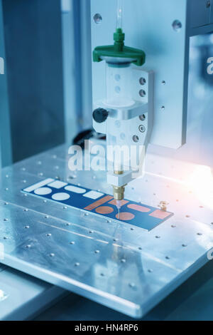 Robot holding glue syringe Injection Stock Photo