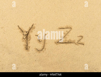 alphabet letters handwritten in sand on beach Stock Photo