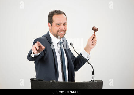 A male auctioneer in action holing a gavel during a live auction. Stock Photo