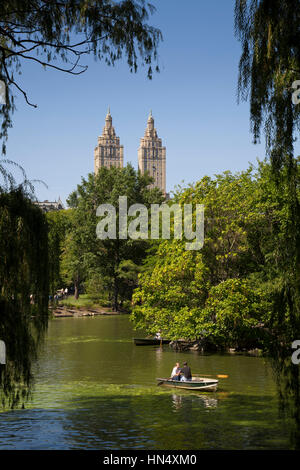 New York City, United States - September, 20 2008: People rowing on the lake in Central Park, Manhattan. The distinctive towers of the San Remo apartm Stock Photo