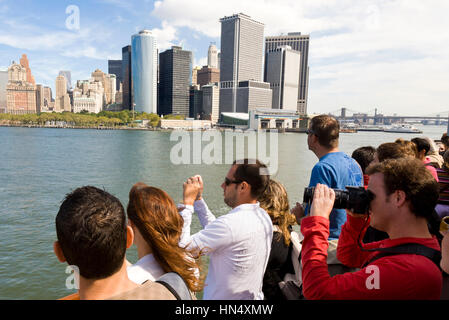 NEW YORK - SEPTEMBER 17 : Tourists on the Staten Island Ferry look out onto Battery park and the Downtown area of Manhattan, New York City on 17th Sep Stock Photo