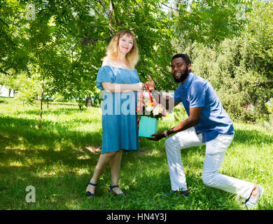 Happy young romantic couple in love. Black man and white woman. Love story and people's attitudes. Beautiful marriage concept. Stock Photo