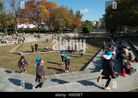 Young Japanese students, school children playing, having fun in Central Park (Chuo Koen) in Hiroshima, Japan, Asia Stock Photo