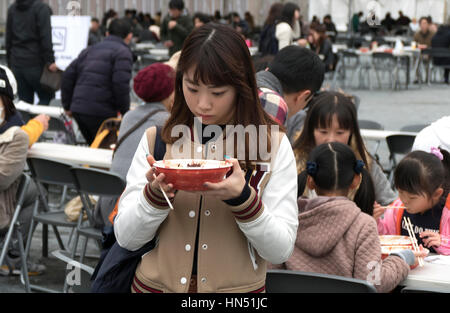 Japanese people, families, tourists eating traditional Asian street food at city fair. Hiroshima, Japan, Asia Stock Photo