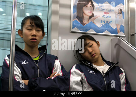 Asian people, Japanese girls, commuters napping while traveling on a local train in Tokyo, Japan, Asia. Railway, transportation Stock Photo