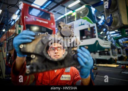 A young teenage apprentice fitter mechanic fixing broken down double decker bus engine at Stagecoach bus operators Wythenshawe depot in Manchester, En Stock Photo