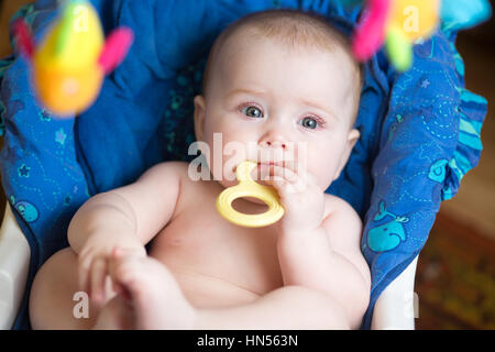 Funny chubby baby with teether in mouth Stock Photo