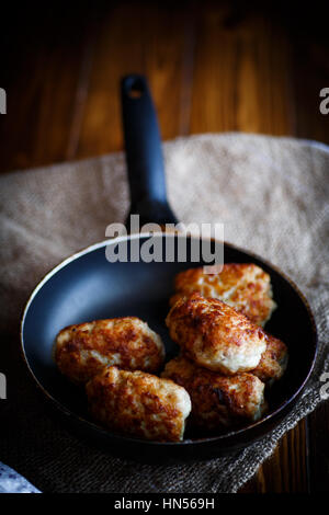 fried pork chops in a frying pan on a wooden table Stock Photo