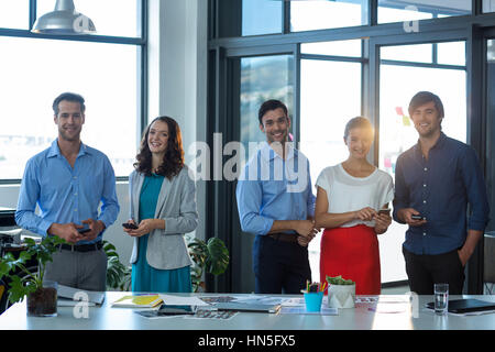 Team of graphic designers using mobile phone in office Stock Photo