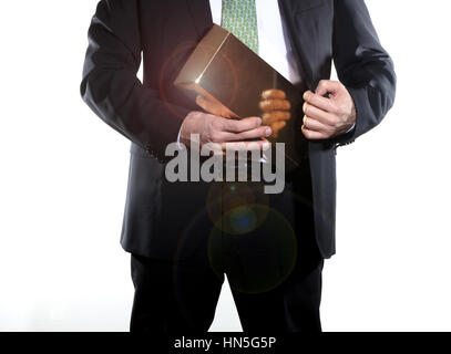 successful businessman keeping a big gold ingot into his suit Stock Photo