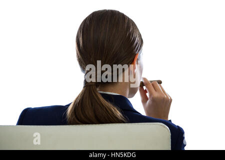 Rear view of businesswoman holding cigar against white background Stock Photo