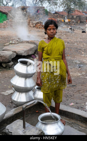 INDIA, state Jharkhand, Jharia Dhanbad , parts of Jharia are located above smolding underground coal seams and will be displaced due to extended opencast coal mining by BCCL Ltd. of Coal India, people fetch water from well Stock Photo