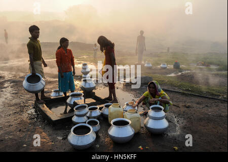 INDIA, state Jharkhand, Jharia Dhanbad , parts of Jharia are located above smolding underground coal seams and will be displaced due to extended opencast coal mining by BCCL Ltd. of Coal India, people fetch water in the morning Stock Photo