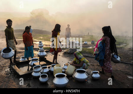 INDIA, state Jharkhand, Jharia Dhanbad , parts of Jharia are located above smolding underground coal seams and will be displaced due to extended opencast coal mining by BCCL Ltd. of Coal India, people fetch water in the morning Stock Photo