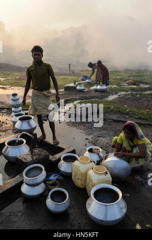 INDIA, state Jharkhand, Jharia Dhanbad , parts of Jharia are located above smolding underground coal seams and will be displaced due to extended opencast coal mining by BCCL Ltd. of Coal India, people fetch water in the morning Stock Photo