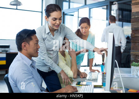 Graphic designers interacting while working on personal computer in office Stock Photo