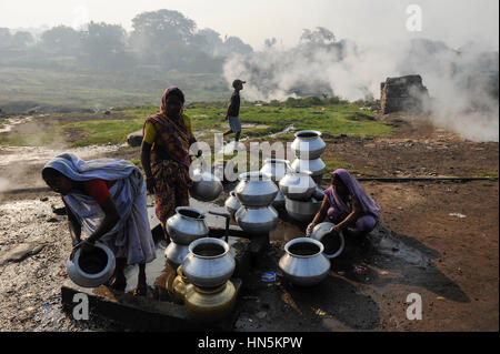 INDIA, state Jharkhand, Jharia Dhanbad , parts of Jharia are located above smolding underground coal seams and will be displaced due to extended opencast coal mining by BCCL Ltd. of Coal India, people fetch water in the morning Stock Photo