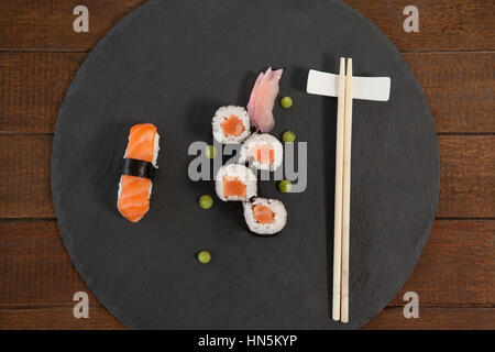 Set of assorted sushi served with chopsticks on black stone slate on wooden table Stock Photo