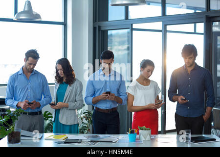 Team of graphic designers using mobile phone in office Stock Photo