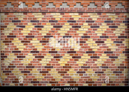 Ornamentally designed patterned brick wall on the side of a building. Stock Photo