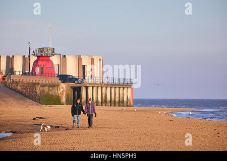 dog walker on the sand  at Liverpool bay New Brighton beach in Wallasey, Merseyside, Wirral, England, UK Stock Photo