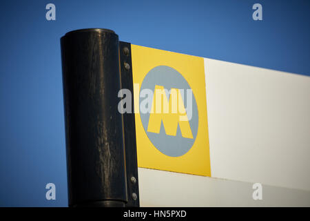 Blue sky on a sunny day Merseyrail commuter rail network M logo on information station sign  in  Wallasey, Merseyside, Wirral, England, UK. Stock Photo